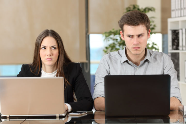 Front view of two angry people using computers