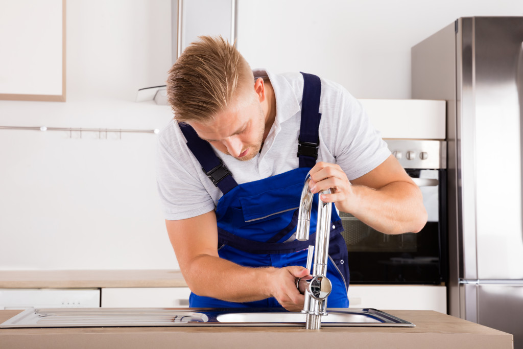 plumber fixing the kitchen faucet