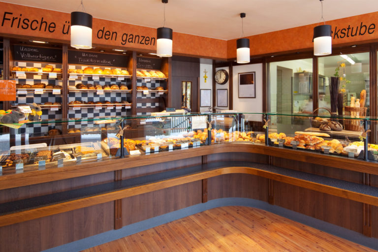 Modern bakery interior with glass display counters full of scrumptious bread and pastries