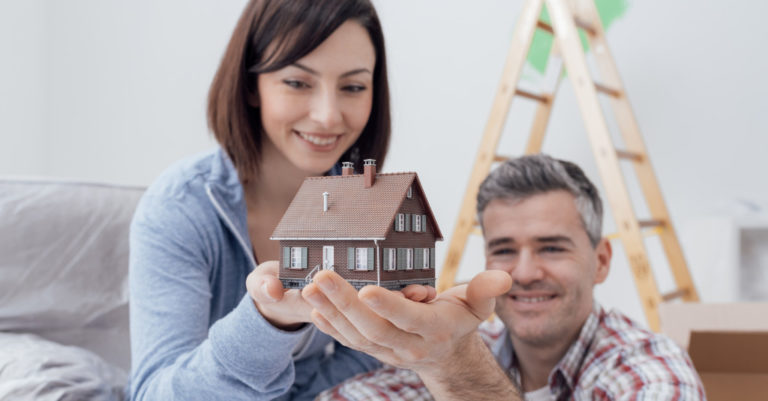 couple holding a house toy