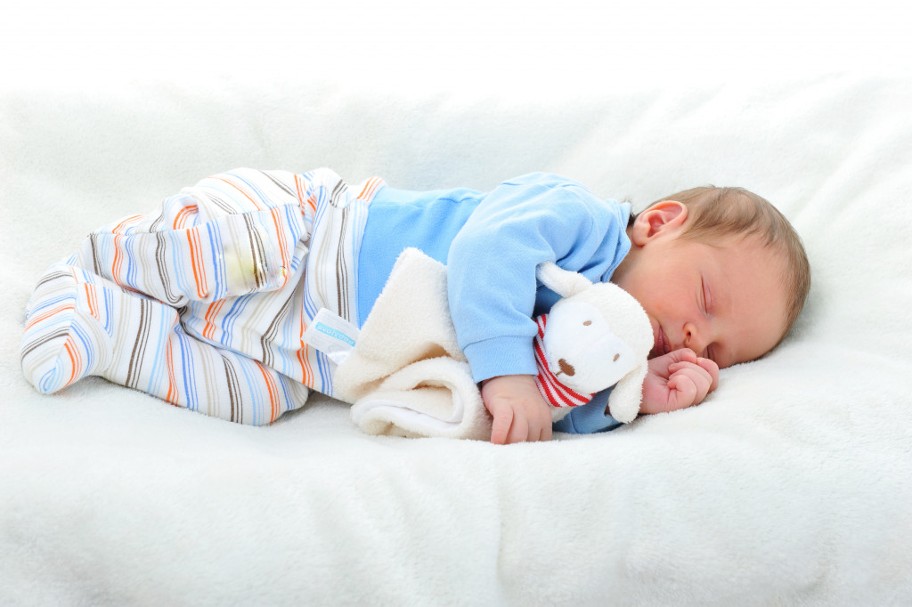 baby hugging a stuffed toy while sleeping