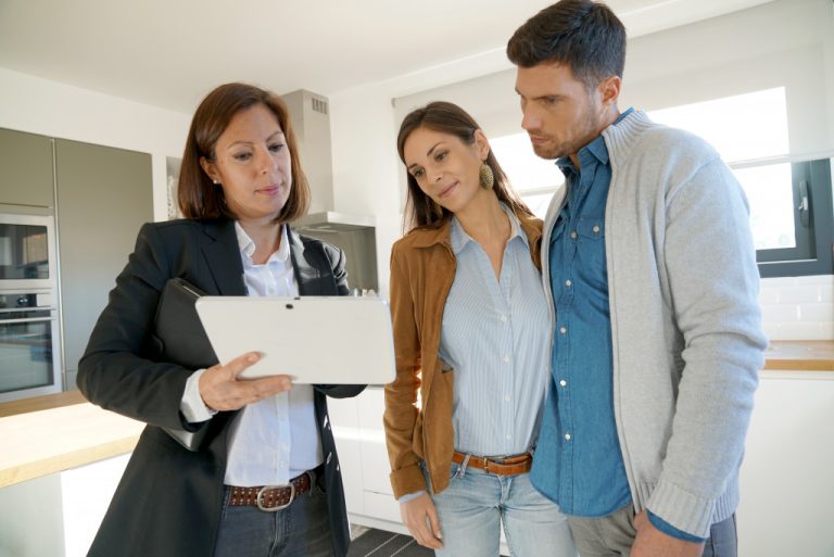 real estate agent showing something with her clients