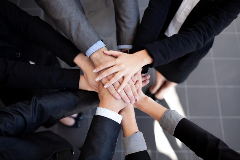 a set of employees joining hands