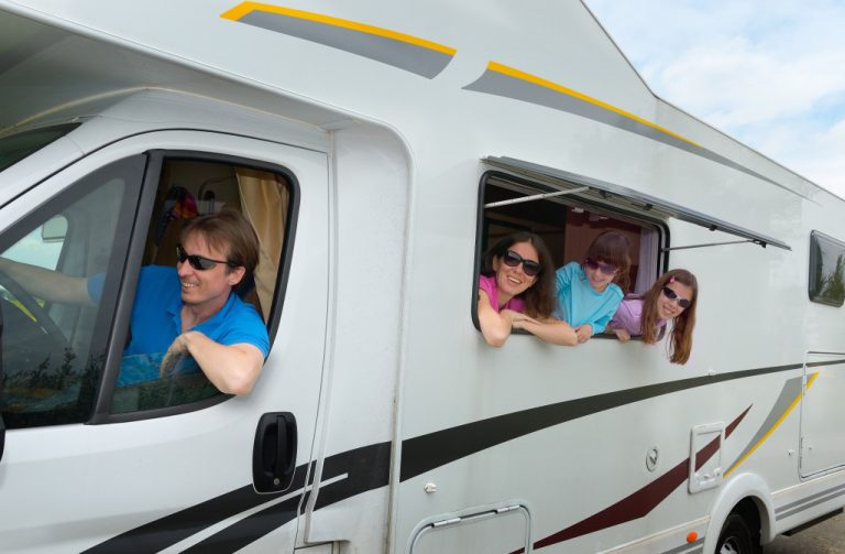 happy parents with children on holiday trip in motorhome